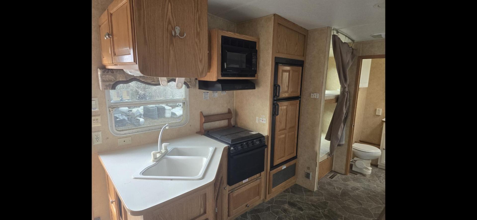 2006 White Pilgrim 5th wheel , located at 923 US HWY 87 E., Billings, MT, 59101, (406) 245-0456, 45.795788, -108.451881 - This is a very nice 1/2 ton towable 27' fifth wheel with a full super slide. Front queen walk around bed and rear double bunks. Couch and booth dynette both make into beds, could sleep 8. flipped axles for clearance, a/c, forced air heat, hot water, inside/outside showers, full bath shower toilet a - Photo#6
