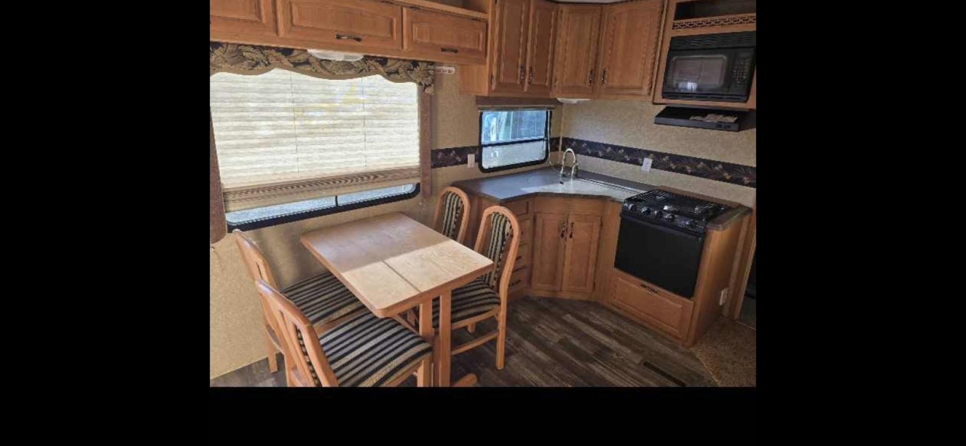 2009 White Keystone Laredo , located at 923 US HWY 87 E., Billings, MT, 59101, (406) 245-0456, 45.795788, -108.451881 - 2009 Keystone Laredo 32RS LOCATED IN BILLINGS MT $11,900 Very nice fifth wheel with two slides and front triple bunks. Rear suite with queen bed. Couch makes into bed. Stand alone kitchen table and chairs. Could sleep 7. Auto awnings and auto front jacks, solid corrian countertops, oak cabinets - Photo#5