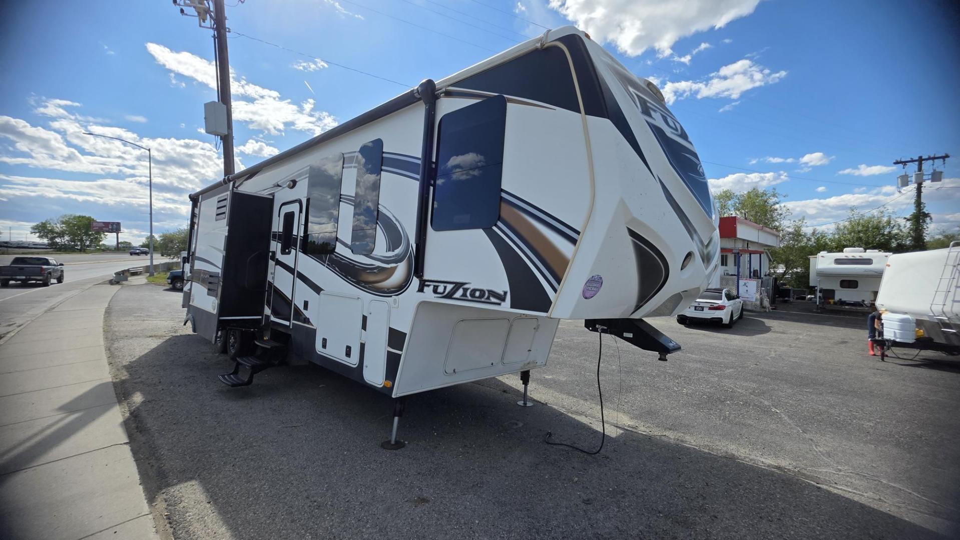 2013 Tan Keystone Fuzion , located at 923 US HWY 87 E., Billings, MT, 59101, (406) 245-0456, 45.795788, -108.451881 - 2013 Keystone Fuzion FZ342 Located in Billings MT $29,900 This is a gorgeous 5th wheel toy hauler. 3 slides, 3 tvs, solid surface corion countertops, dual a/c, 10 Gallon hot water heater with DSI, full bath shower toilet. Solar panels, auto leveling jacks, fuel station, fireplace, central vac, r - Photo#1