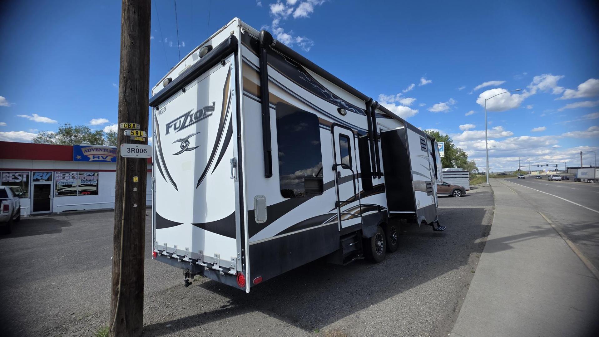 2013 Tan Keystone Fuzion , located at 923 US HWY 87 E., Billings, MT, 59101, (406) 245-0456, 45.795788, -108.451881 - 2013 Keystone Fuzion FZ342 Located in Billings MT $29,900 This is a gorgeous 5th wheel toy hauler. 3 slides, 3 tvs, solid surface corion countertops, dual a/c, 10 Gallon hot water heater with DSI, full bath shower toilet. Solar panels, auto leveling jacks, fuel station, fireplace, central vac, r - Photo#2
